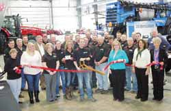 RIBBON CLIPPED—Brian Mattmiller, flanked by the crew at Swiderski Equpment Inc. and members of the Antigo/Langlade County Chamber of Commerce, clips the ribbon officially opening the expanded service center this week. Dating to the days of training work horses, Swiderski now operates five locations with 124 employees. The Antigo dealership is located just north of the city limits.