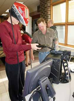 Bradley Westen tries out the virtual welding equipment brought to this morning’s career fair from Northcentral Technical College. At right is NTC welding instructor Darren Wild.