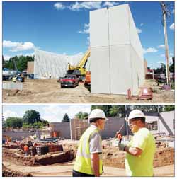 WALLS ARE RISING—Work is proceeding at a breakneck pace on the Elcho school addition. In the top photo, a crane sets one of the huge concrete precasts that make up the new gymnasium walls into place. In the lower photo, Earl Doc Smith of EDS Builders consults with one of the contractors on site as the walls advance in the new administrative and academic area of the complex.