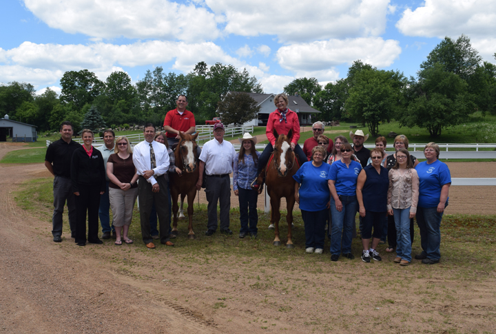 Jeff Anderson of the Wisconsin Department of Tourism and Shaughn Novy, event organizer for the Northwoods Triple Crown event in August, pose atop horses with friends and supporters at the Black Hawk Hill Horse Park.