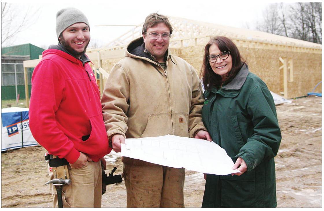 Marge Gibson, executive director of Raptor Education Group Inc., looks over the plans for the new clinic with Jake Reif (left) and Jerry Reif of Reif Construction, the general contractor for the project.