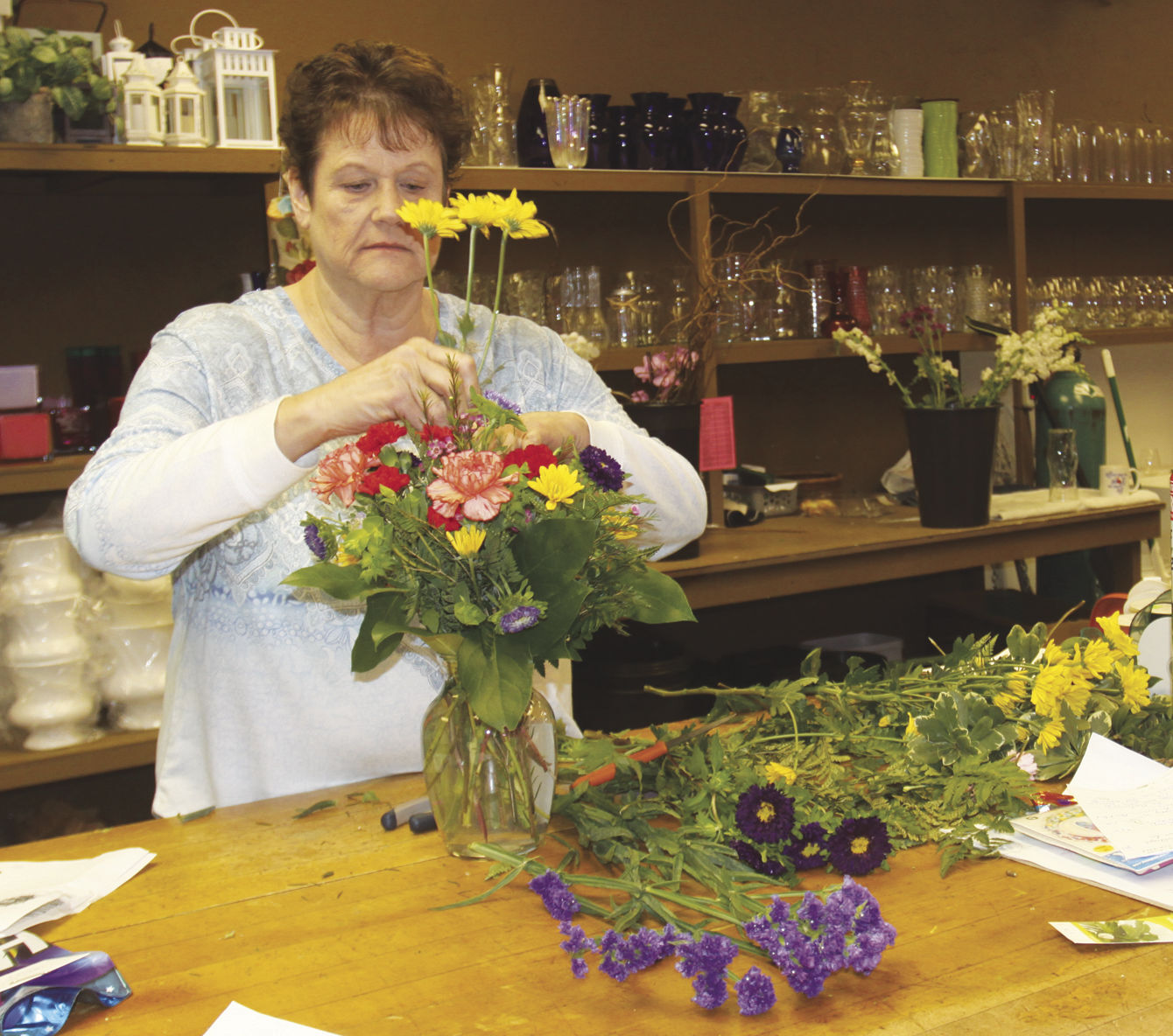 Jeanne Kakes designs a birthday bouquet at Flowers fromt he Heart on Fifth.  The lead designer will join the other eight employees when the move into the larger building in April.