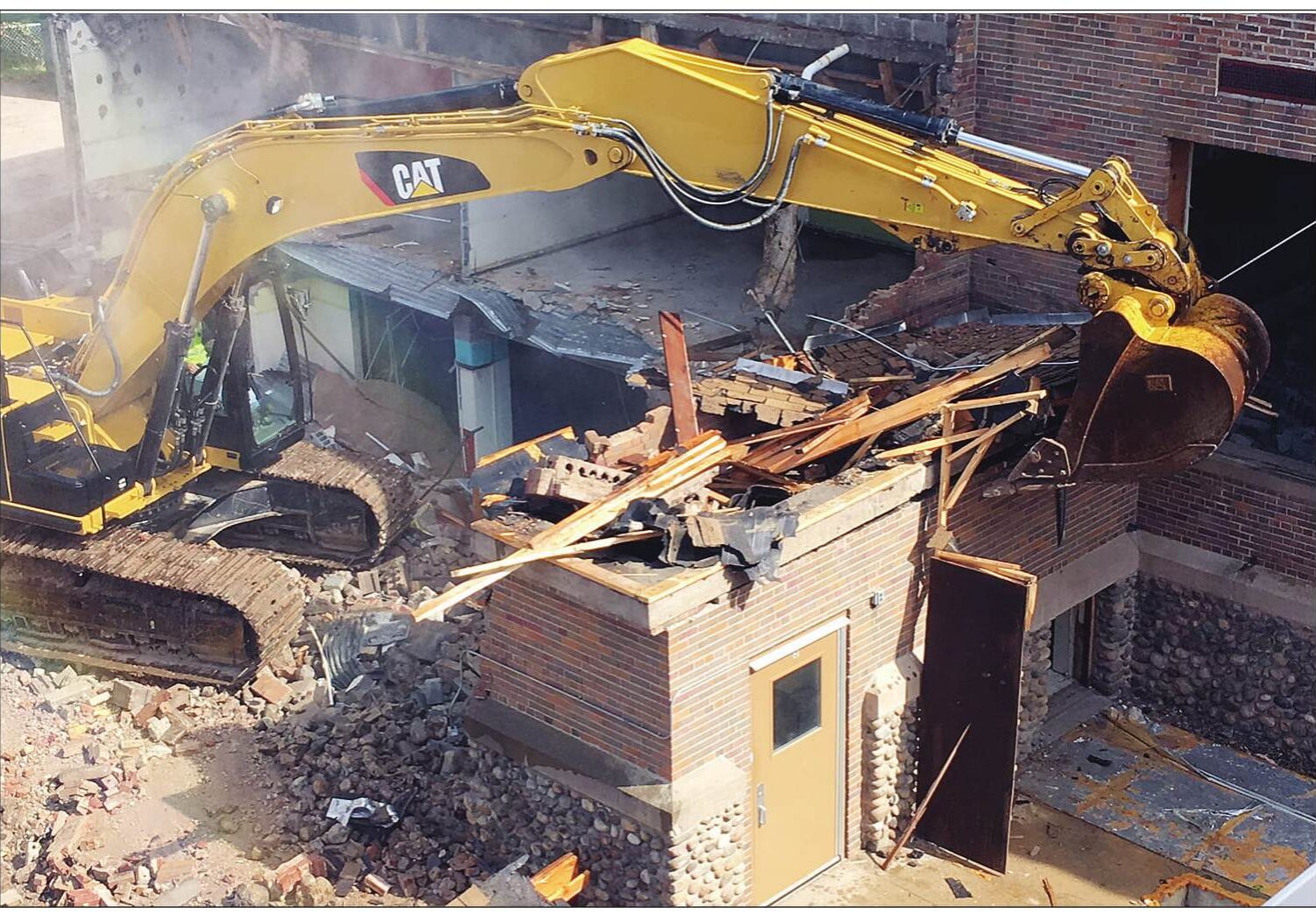 Heavy equipment clawed into the west side of the old Elcho elementary school on Monday, just feet from where students were having class in the new building. It's a careful process.