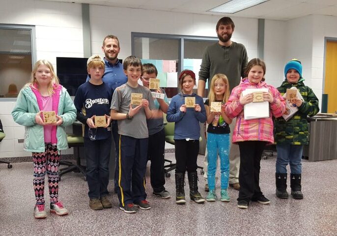 Andy Bauknecht from Rexnord-Merit Gear (back left) and Tim Krueger, AHS Fab Lab Coordinator (back right) post with the Elementary STEM Scouts and their finished projects.