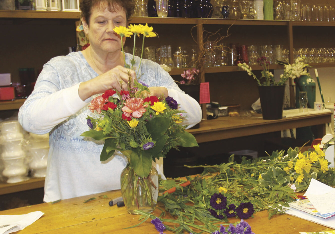 Jeanne Kakes designs a birthday bouquet at Flowers fromt he Heart on Fifth.  The lead designer will join the other eight employees when the move into the larger building in April.