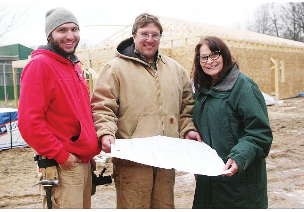 Marge Gibson, executive director of Raptor Education Group Inc., looks over the plans for the new clinic with Jake Reif (left) and Jerry Reif of Reif Construction, the general contractor for the project.